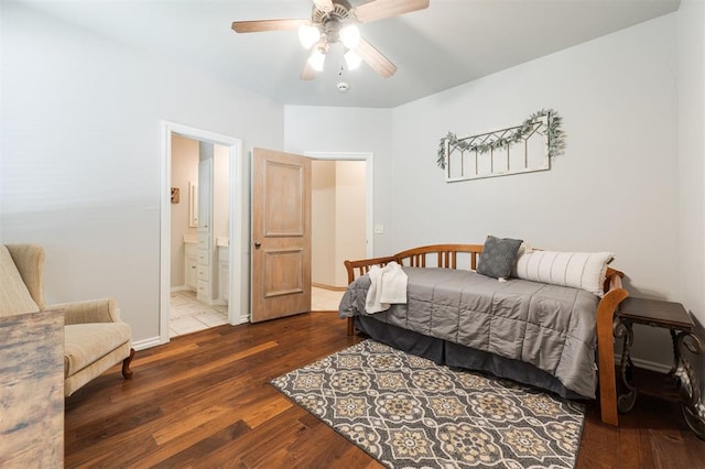 bedroom featuring wood finished floors, ensuite bath, a ceiling fan, and baseboards