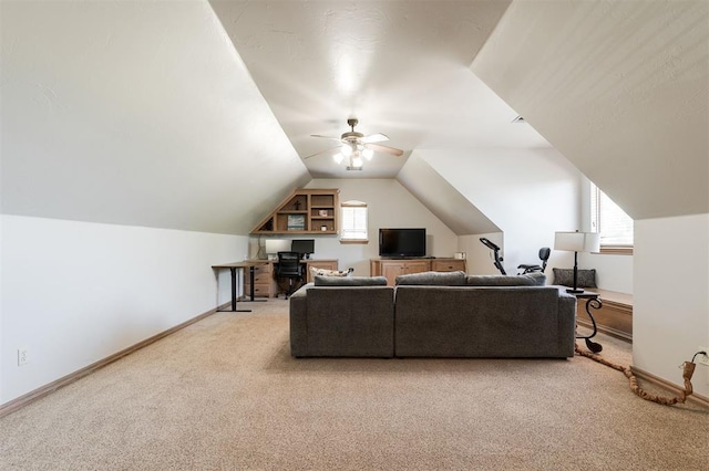 living area with light carpet, ceiling fan, baseboards, an office area, and vaulted ceiling