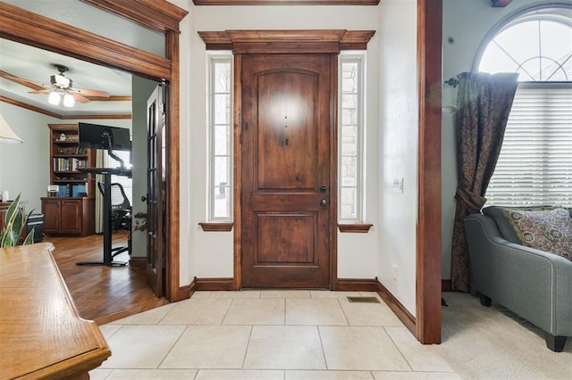 foyer featuring baseboards, ceiling fan, and light tile patterned flooring