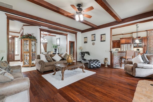 living area featuring beamed ceiling, a ceiling fan, wood-type flooring, and baseboards