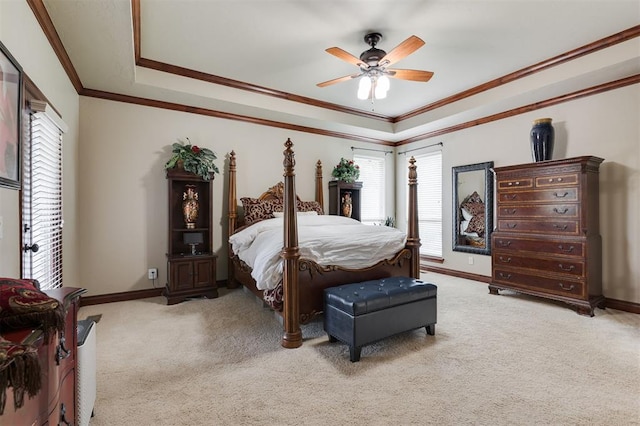 bedroom with a raised ceiling, light colored carpet, baseboards, crown molding, and a ceiling fan