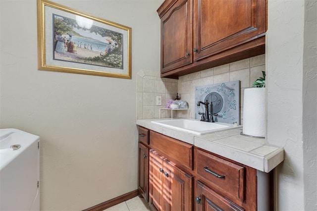 laundry area featuring cabinet space and light tile patterned flooring