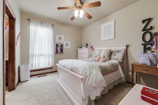 carpeted bedroom featuring multiple windows, ceiling fan, and baseboards