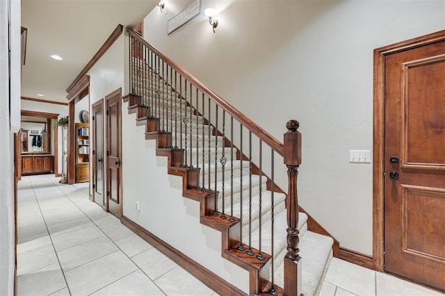stairs featuring tile patterned flooring, baseboards, crown molding, and recessed lighting