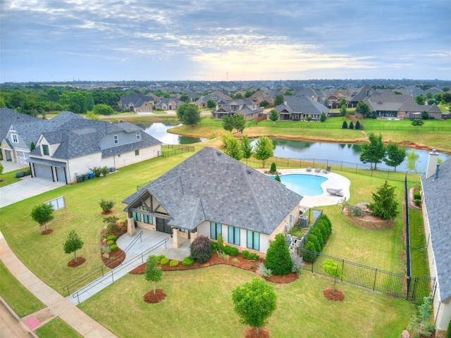 aerial perspective of suburban area featuring a nearby body of water and a pool