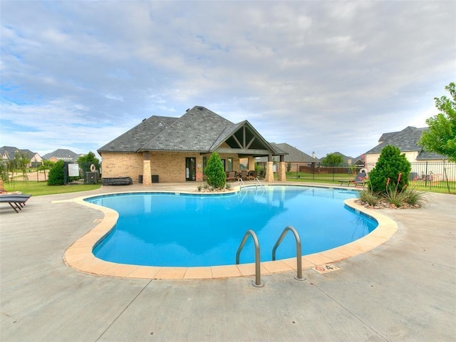 community pool featuring fence and a patio area