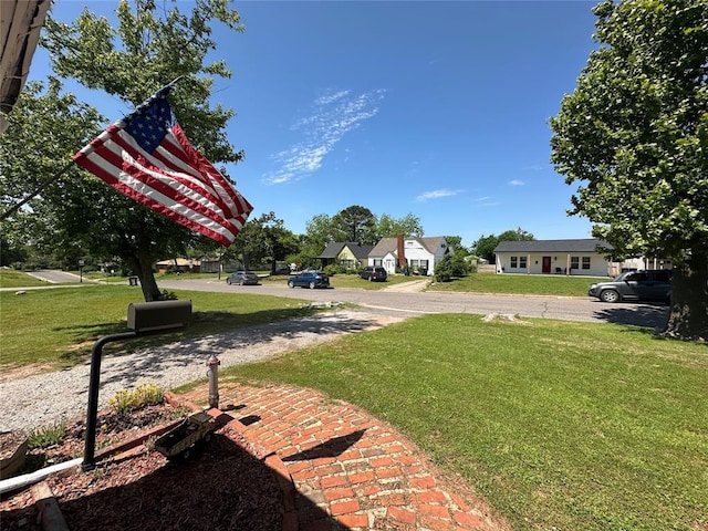 view of green lawn with a residential view