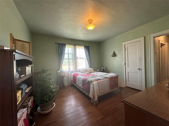 bedroom with dark wood-style flooring and a textured ceiling