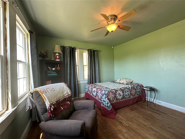 bedroom with baseboards, wood finished floors, and a ceiling fan