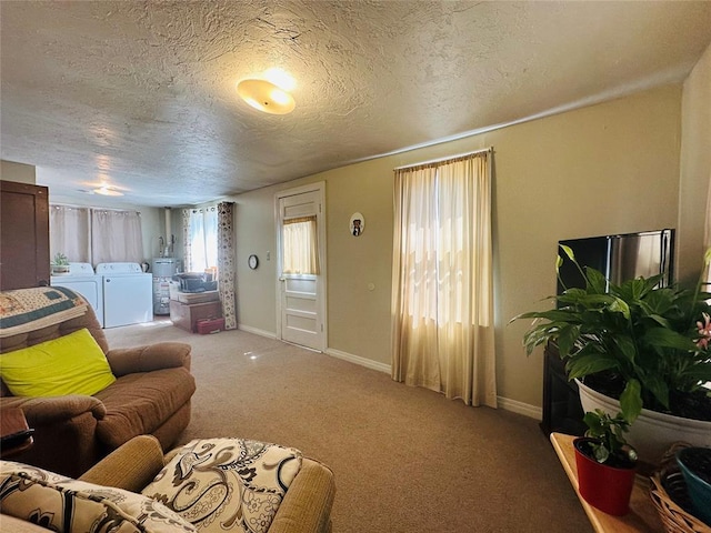 carpeted living area featuring separate washer and dryer, a textured ceiling, baseboards, and gas water heater