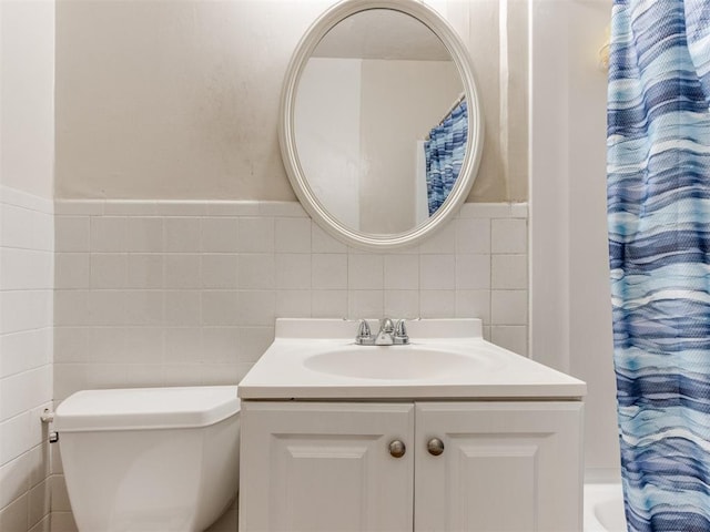 2210 SW 52nd St, Oklahoma City, OK 73119 - bathroom featuring tile walls, vanity, toilet, and a wainscoted wall