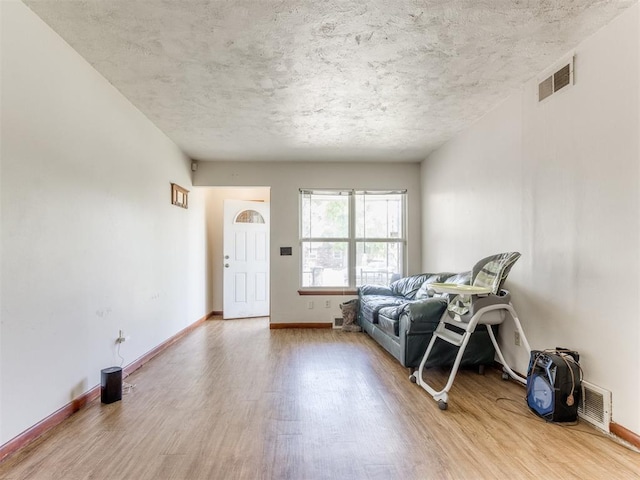 2210 SW 52nd St, Oklahoma City, OK 73119 - living room featuring wood finished floors, baseboards, and a textured ceiling