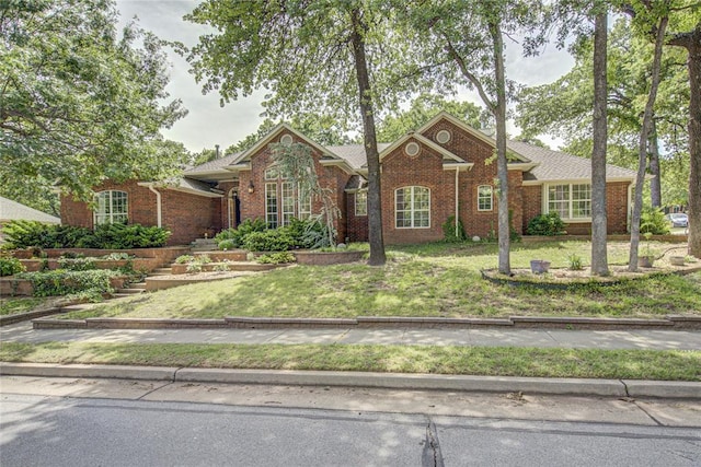 view of front of home featuring brick siding and a front yard