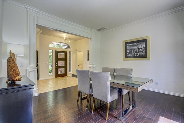 dining area with hardwood / wood-style flooring, baseboards, crown molding, and a chandelier