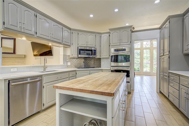 kitchen featuring gray cabinetry, stainless steel appliances, open shelves, and recessed lighting