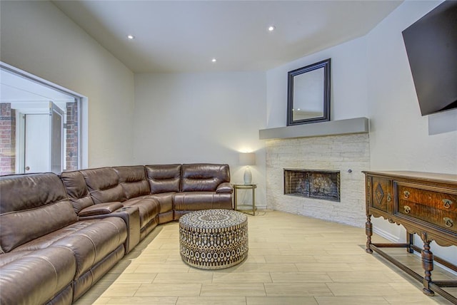 living room featuring light wood-type flooring, a fireplace, and recessed lighting
