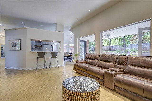living room with healthy amount of natural light, baseboards, recessed lighting, and wood finished floors
