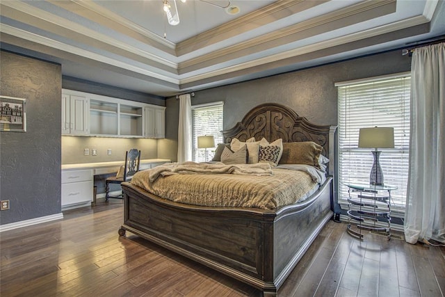 bedroom featuring a raised ceiling, ornamental molding, dark wood finished floors, and a textured wall