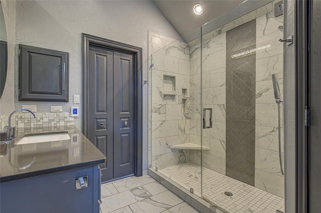 full bathroom with marble look tile flooring, lofted ceiling, a shower stall, and vanity