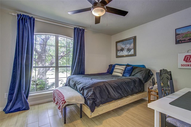 bedroom featuring multiple windows, ceiling fan, and wood finished floors