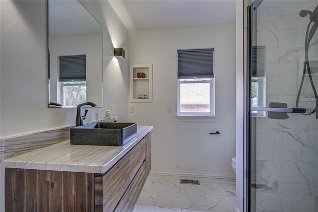 full bathroom featuring marble finish flooring, a marble finish shower, toilet, and vanity