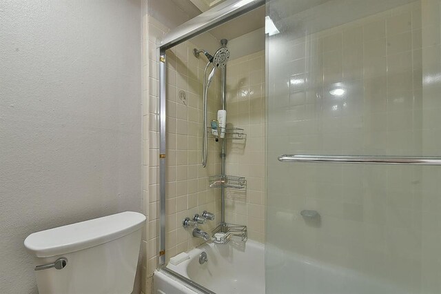 807 Cardinal Creek Blvd Unit C, Norman, OK 73072 - full bathroom with bath / shower combo with glass door, toilet, and a textured wall