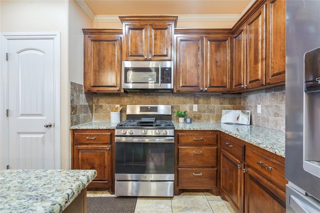 kitchen with appliances with stainless steel finishes, ornamental molding, tasteful backsplash, and light stone counters