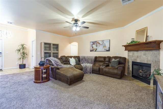 tiled living area with ceiling fan, crown molding, a tile fireplace, carpet floors, and arched walkways