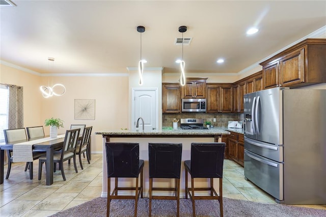 kitchen featuring appliances with stainless steel finishes, ornamental molding, backsplash, a center island, and a sink