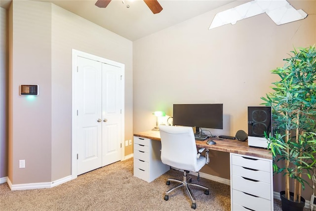 office space with light colored carpet, ceiling fan, and baseboards