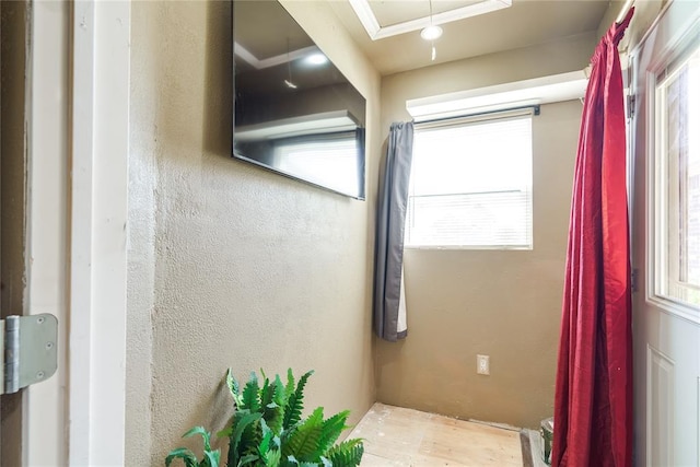 bathroom featuring plenty of natural light and a textured wall