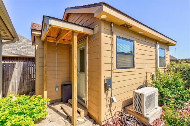view of outbuilding with a cooling unit and fence