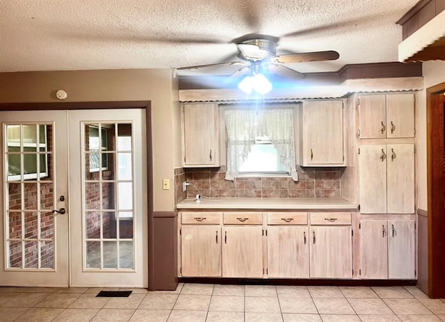 kitchen featuring a ceiling fan, light countertops, french doors, a textured ceiling, and tasteful backsplash