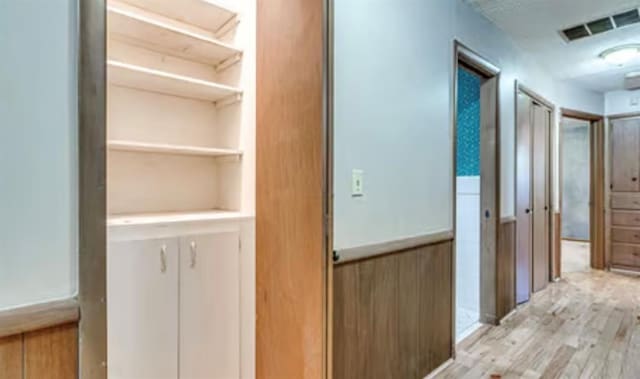 18906 13th St, Shawnee, OK 74801 - corridor with light wood-style flooring and built in shelves