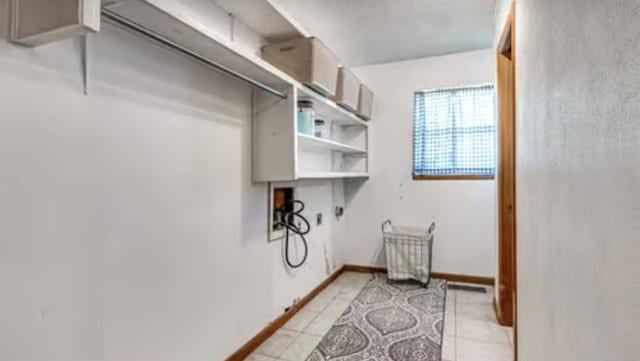 18906 13th St, Shawnee, OK 74801 - laundry area with light tile patterned floors and baseboards