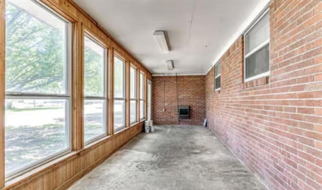 18906 13th St, Shawnee, OK 74801 - unfurnished sunroom with brick wall and unfinished concrete flooring