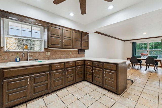 805 John F Kroutil Dr, Yukon, OK 73099 - kitchen with a sink, ceiling fan, light countertops, a peninsula, and decorative backsplash