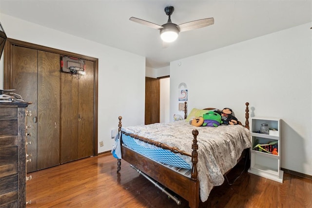 805 John F Kroutil Dr, Yukon, OK 73099 - bedroom with wood finished floors, baseboards, ceiling fan, and a closet