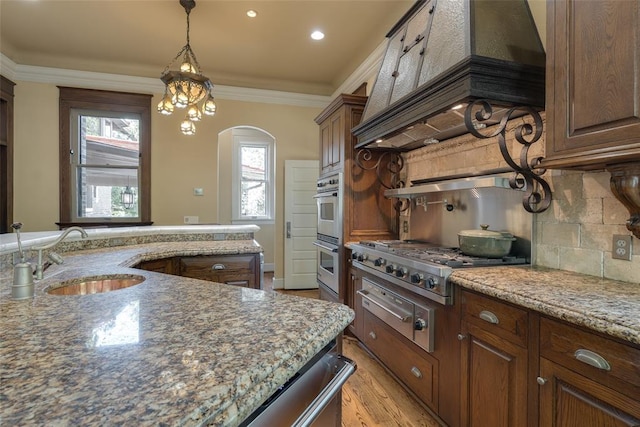 1415 N Hudson Ave, Oklahoma City, OK 73103 - kitchen with a sink, a warming drawer, stainless steel appliances, tasteful backsplash, and arched walkways