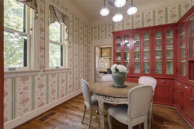 1415 N Hudson Ave, Oklahoma City, OK 73103 - dining space featuring wood finished floors, wallpapered walls, and baseboards