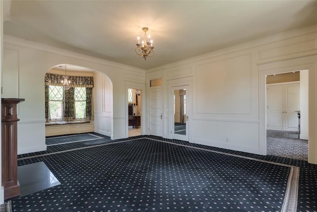 1415 N Hudson Ave, Oklahoma City, OK 73103 - foyer entrance featuring a decorative wall, a chandelier, arched walkways, and dark colored carpet