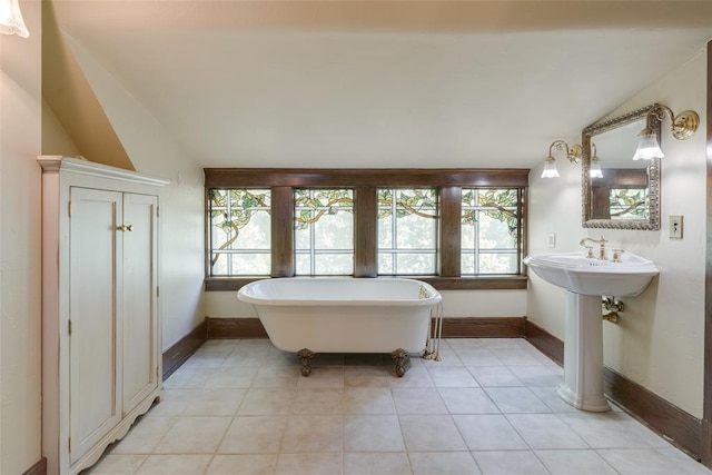 1415 N Hudson Ave, Oklahoma City, OK 73103 - bathroom featuring lofted ceiling, a freestanding tub, baseboards, tile patterned floors, and a sink