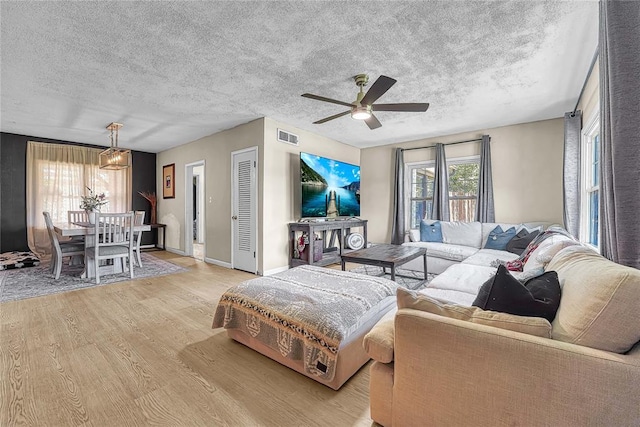 800 N Main St, Thomas, OK 73669 - living room featuring ceiling fan, light wood-style floors, a textured ceiling, and baseboards