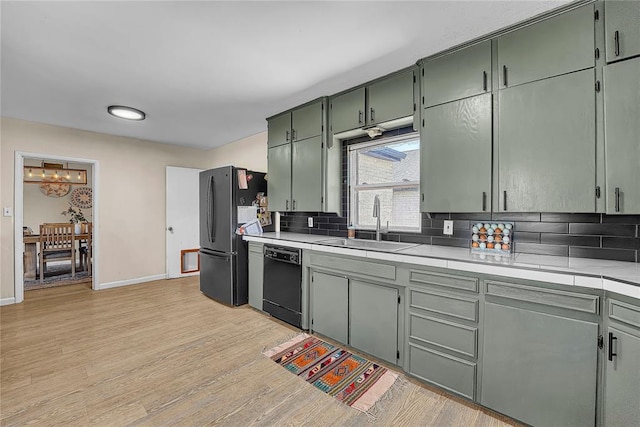 800 N Main St, Thomas, OK 73669 - kitchen with dishwasher, freestanding refrigerator, a sink, decorative backsplash, and light countertops