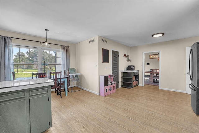 800 N Main St, Thomas, OK 73669 - kitchen with baseboards, light wood finished floors, freestanding refrigerator, light countertops, and decorative light fixtures