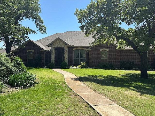 606 Cypress Ct, Blanchard, OK 73010 - french provincial home featuring a front lawn, brick siding, and stone siding