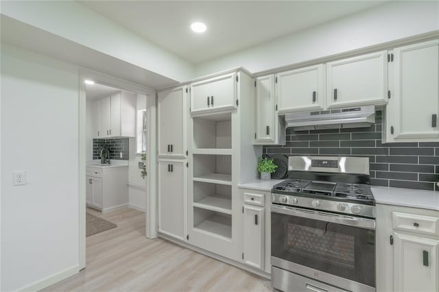 6212 N Utah Ave, Oklahoma City, OK 73112 - kitchen featuring stainless steel gas stove, under cabinet range hood, decorative backsplash, light countertops, and light wood-style floors