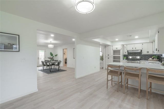 6212 N Utah Ave, Oklahoma City, OK 73112 - kitchen with stainless steel range oven, under cabinet range hood, baseboards, decorative backsplash, and recessed lighting