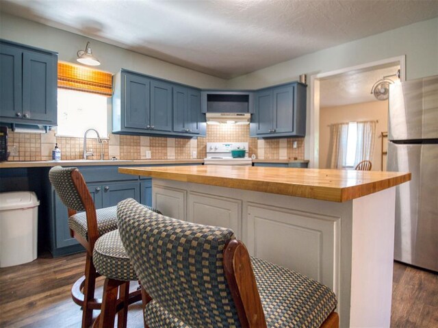 164 4th St, Faxon, OK 73540 - kitchen featuring wood counters, white electric stove, freestanding refrigerator, and blue cabinetry