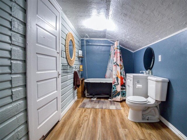 164 4th St, Faxon, OK 73540 - bathroom with wood finished floors, a textured ceiling, toilet, baseboards, and vaulted ceiling